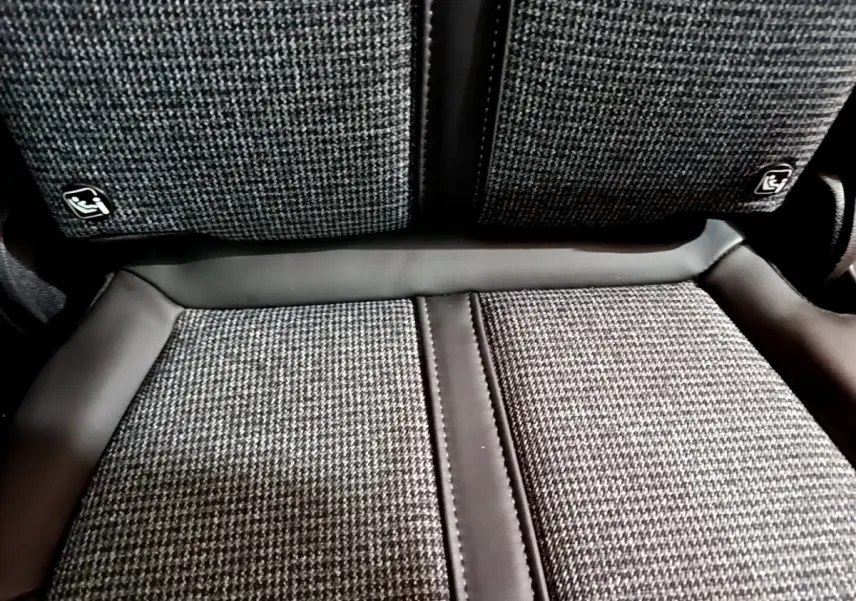 Gros plan sur la banquette arrière tissu gris et cuir noir du Peugeot 5008 Allure 2018, avec fixation Isofix visible.