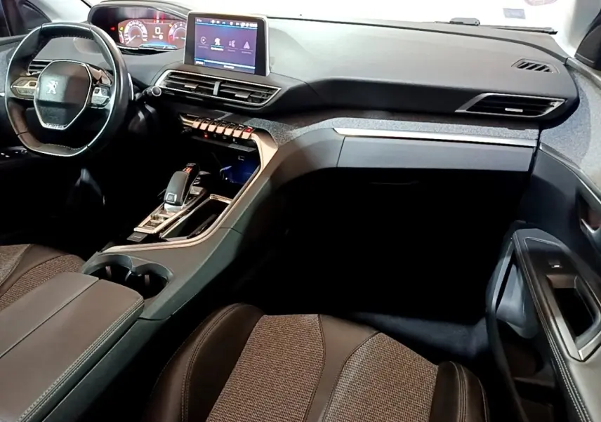 Intérieur Peugeot 5008 bleu, vue côté passager sur tableau de bord moderne avec écran tactile et volant cuir.