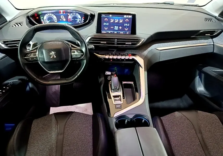 Vue intérieure avant du Peugeot 5008 bleu 2018, tableau de bord avec écran tactile et volant compact cuir multifonctions.