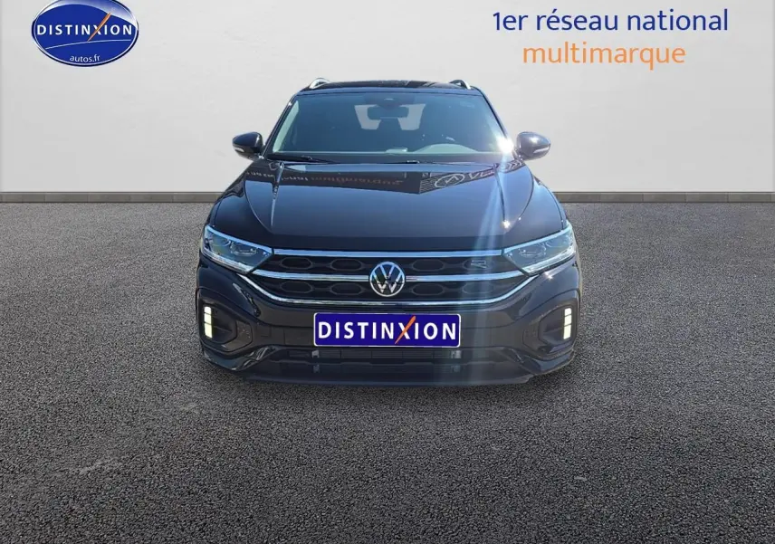 Volkswagen T-Roc noir perle vu de face avec calandre R-Line et feux LED allumés.