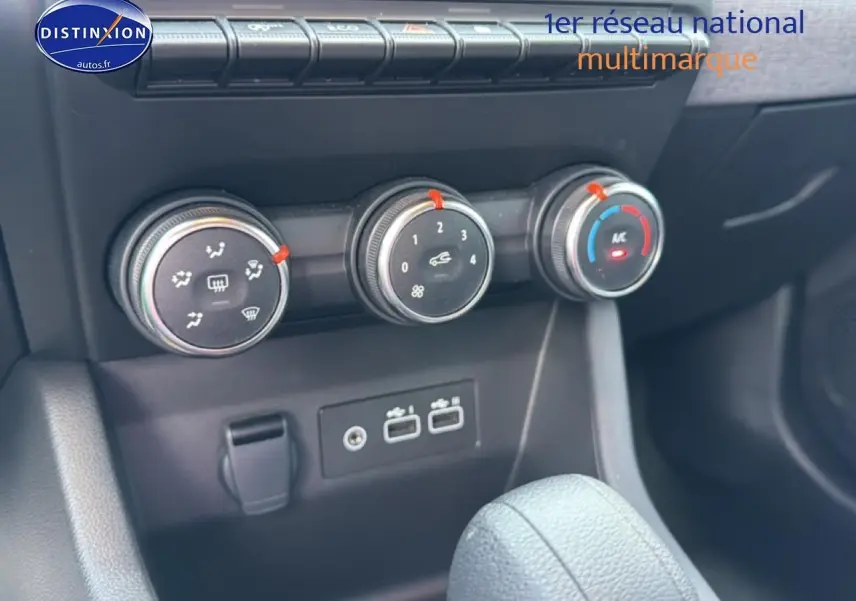 Gros plan sur les commandes de climatisation manuelle et les prises USB du Renault Clio V gris, intérieur avant.