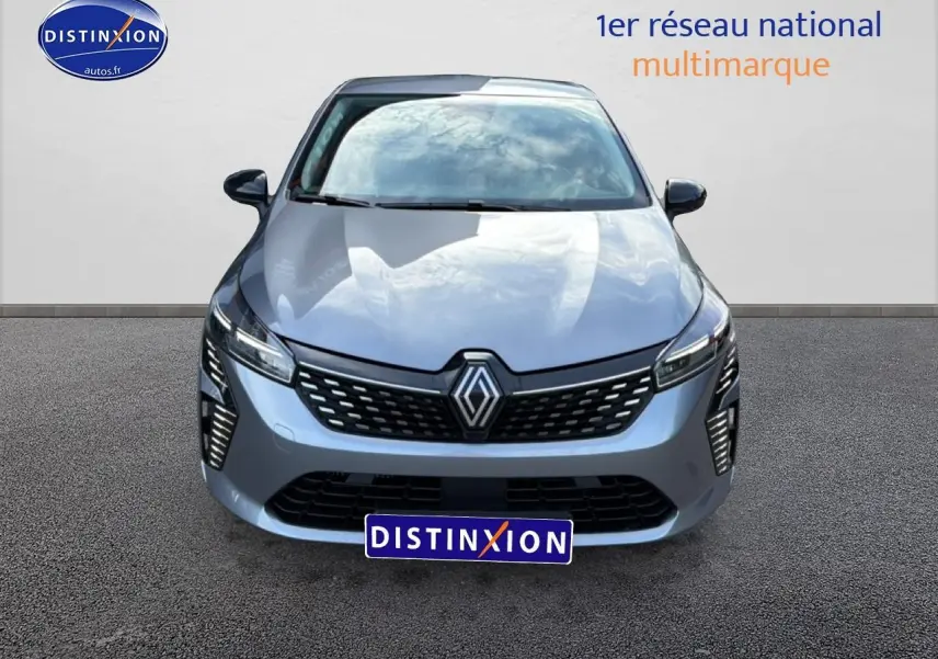 Vue avant d'une Renault Clio V gris métallisé avec calandre noire et feux LED verticaux allumés.