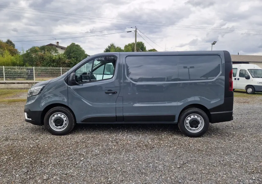 Vue latérale droite d'un Renault Trafic Fourgon gris urbain 2025, avec carrosserie lisse et roues acier.