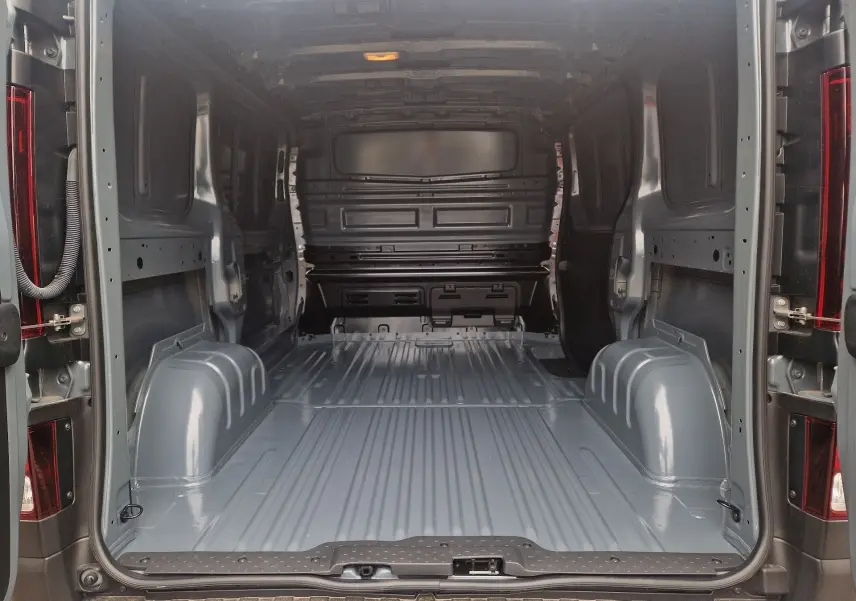 Vue intérieure arrière du Renault Trafic Fourgon gris urbain, montrant l'espace de chargement vide et la cloison avant.