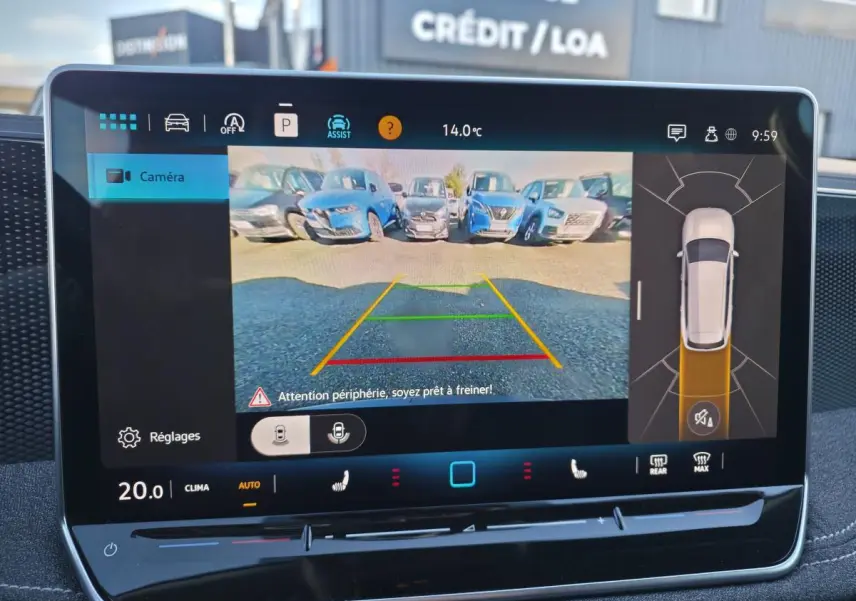 Vue de l'écran tactile intérieur affichant la caméra de recul et l'assistance au stationnement du Volkswagen Passat SW noir.