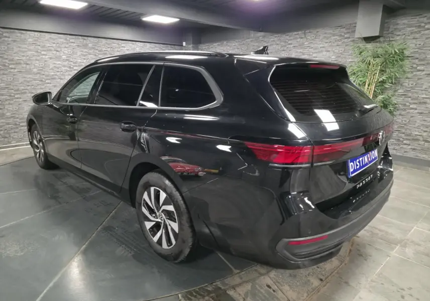 Volkswagen Passat SW noire vue 3/4 arrière droit, avec feux arrière LED et jantes alliage 16 pouces.