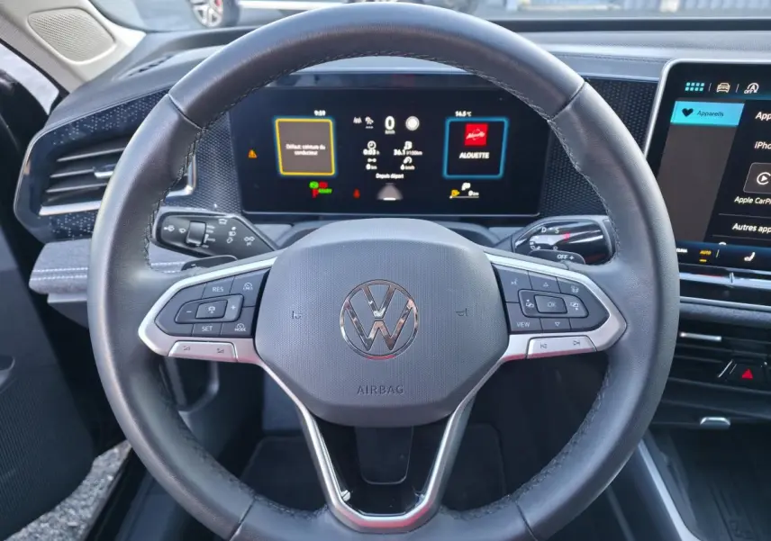 Vue rapprochée du volant cuir multifonction et du tableau de bord numérique de la Volkswagen Passat SW 2024.