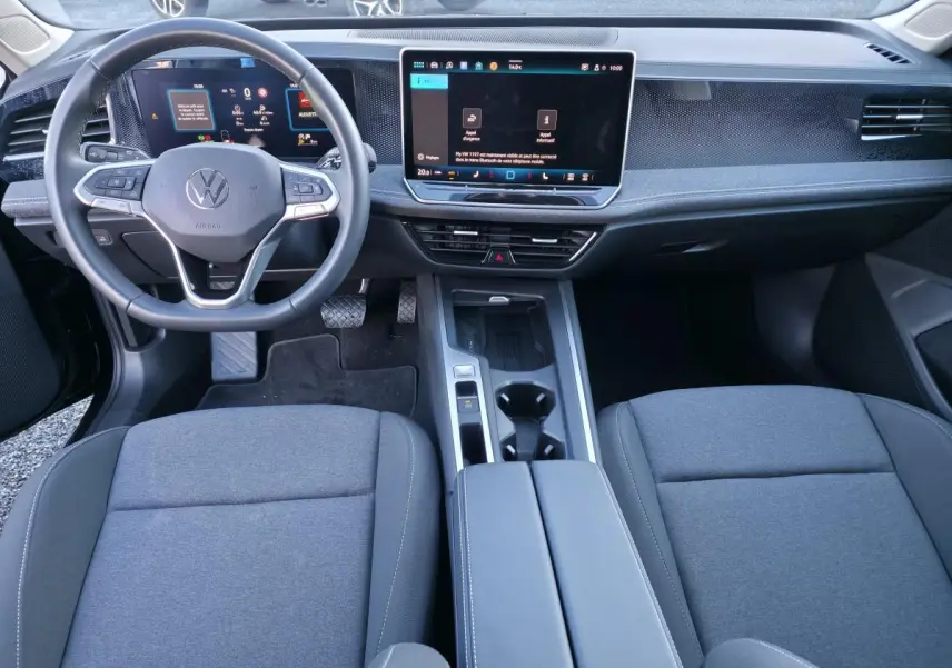 Vue intérieure avant de la Volkswagen Passat SW 2024, tableau de bord numérique et écran tactile 12,9 pouces, sièges gris.