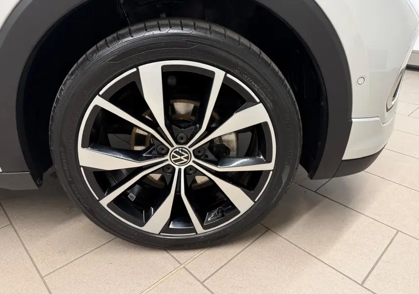 Gros plan sur la jante alliage 18 pouces bicolore du côté avant droit du Volkswagen T-Cross Reflet d'Argent.