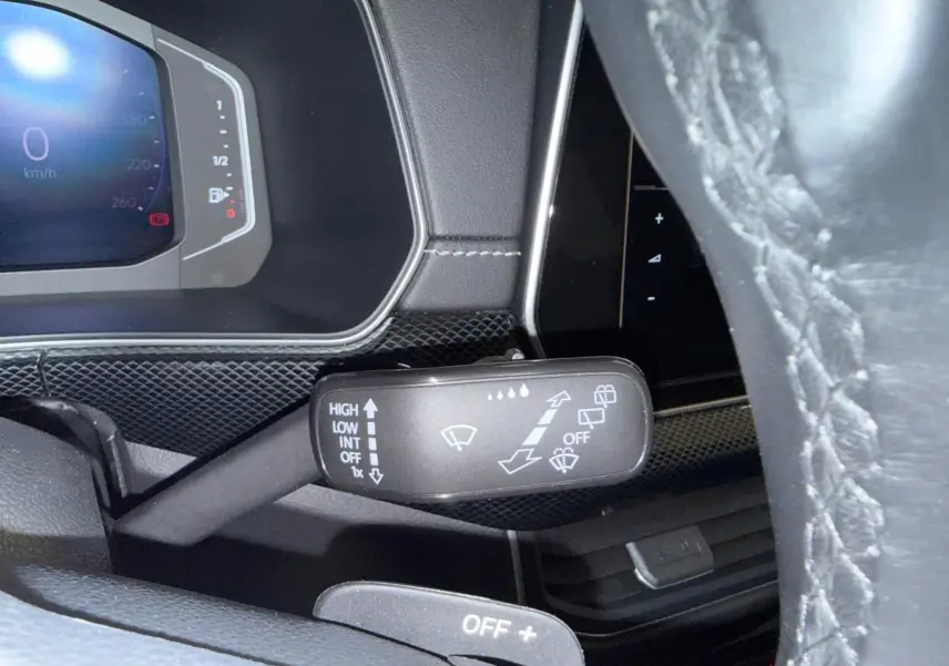 Gros plan sur la commande d'essuie-glace côté gauche du volant du Volkswagen T-Cross 1.5 TSI 150 DSG7 R-Line 2024 couleur Reflet d'Argent.