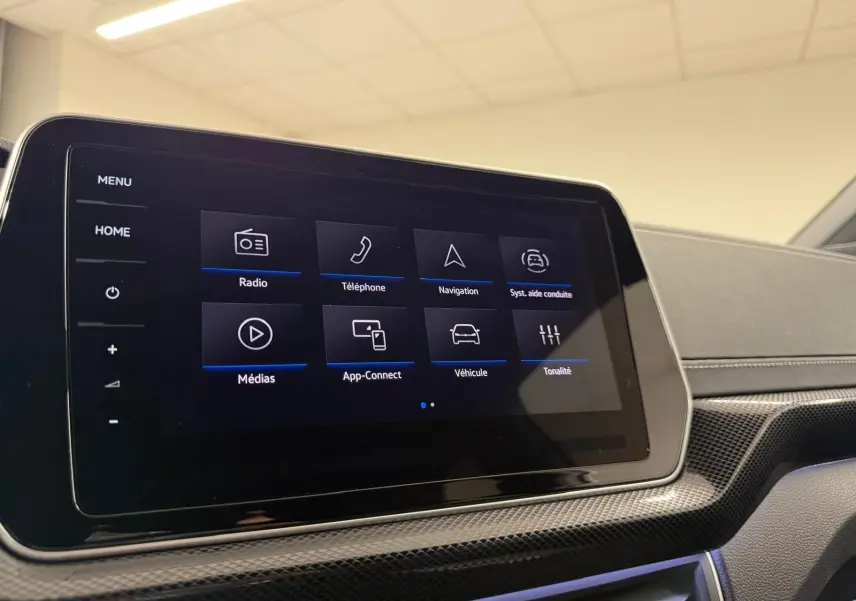 Écran tactile central du Volkswagen T-Cross 1.5 TSI R-Line 2024, affichant le menu principal, intérieur noir.