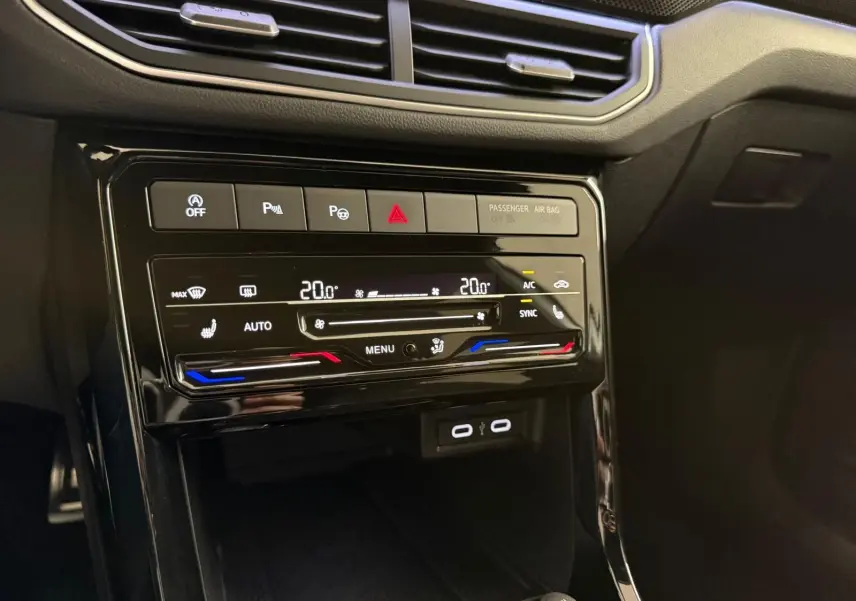 Détail de la console centrale noire brillante du Volkswagen T-Cross 1.5 TSI R-Line avec commandes climatisation tactile bi-zone.