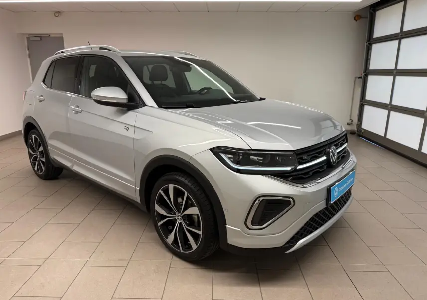 Volkswagen T-Cross 1.5 TSI R-Line en reflet d'argent, vue 3/4 avant droit avec jantes alliage 18 pouces.