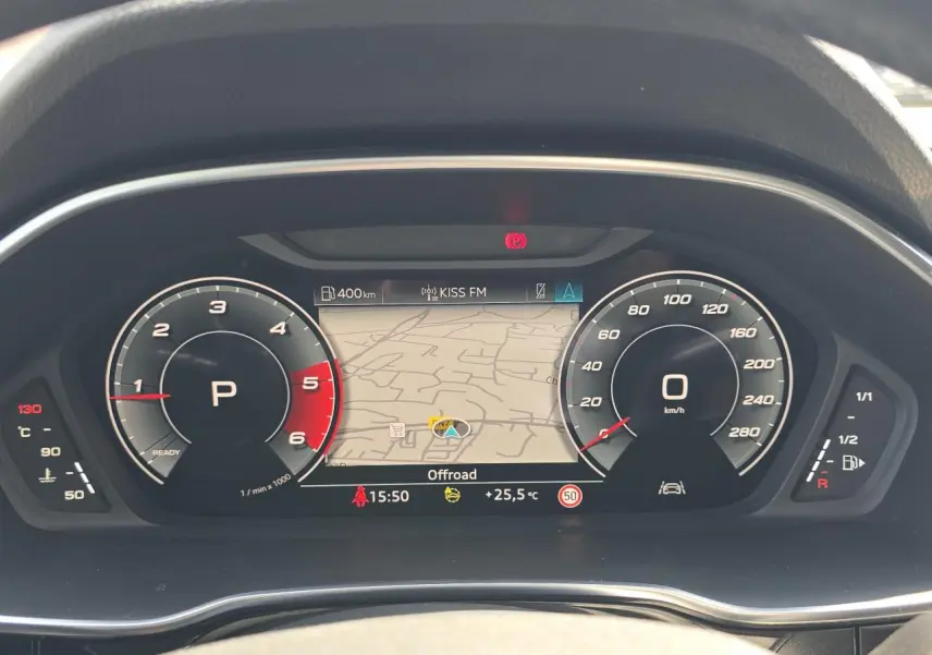 Vue rapprochée du tableau de bord numérique de l'Audi Q3 blanc, affichant la navigation et les compteurs digitaux.