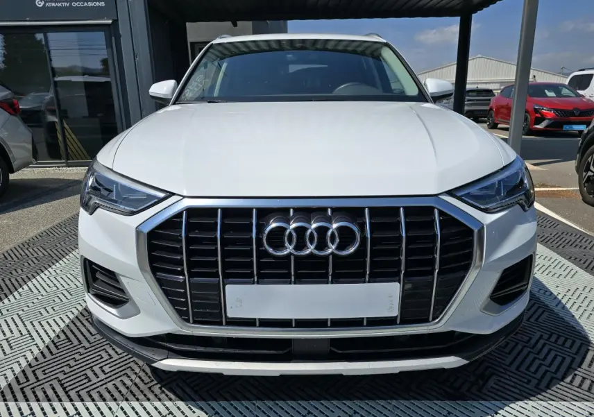 Vue frontale d'un Audi Q3 blanc 2022 avec calandre noire et phares LED au design anguleux.