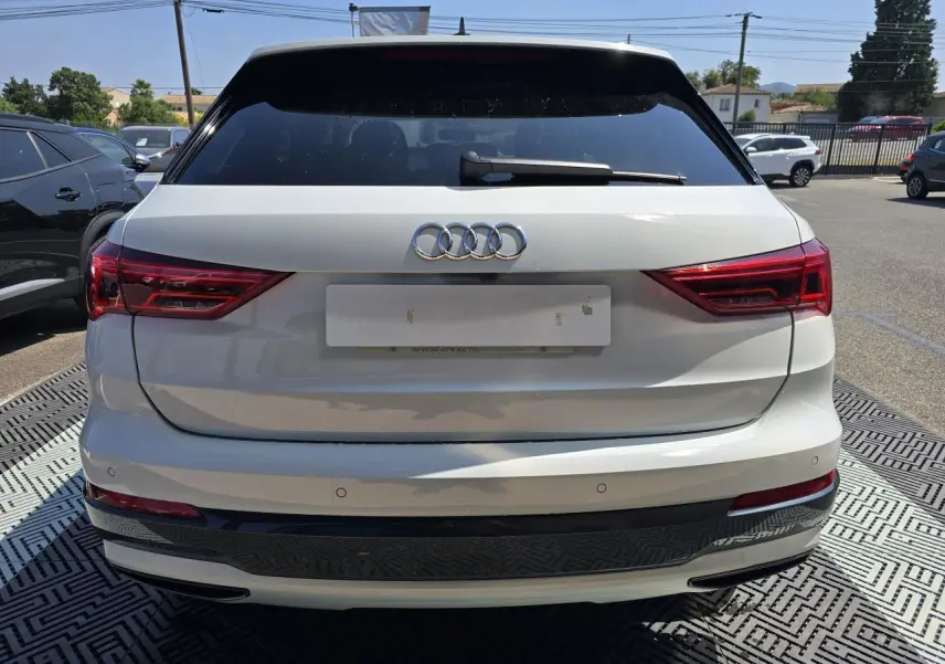 Vue arrière d’un Audi Q3 blanc 2022 avec vitres surteintées et feux LED distinctifs.