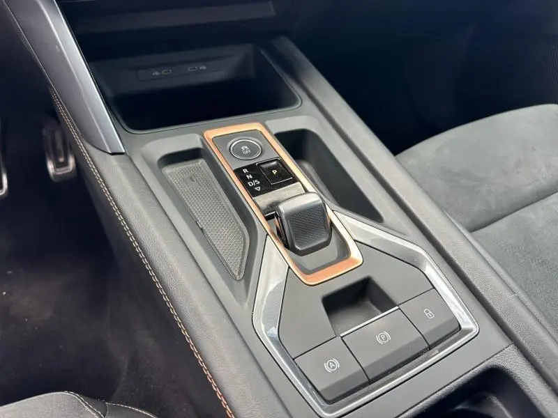 Vue rapprochée de la console centrale noire avec levier de vitesse et surpiqûres marron du CUPRA Formentor blanc Nevada.