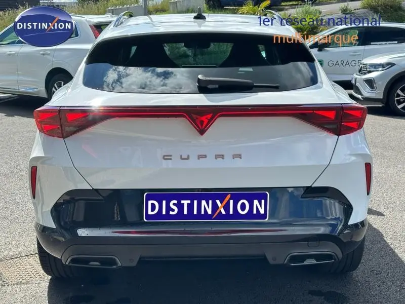 Vue arrière d'une CUPRA Formentor blanc Nevada métallisé avec feux arrière LED et double sortie d'échappement.