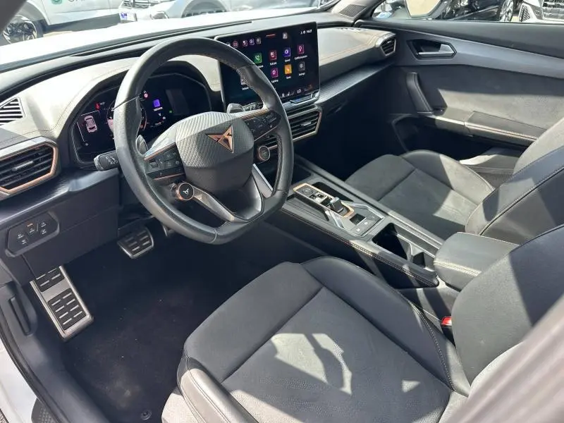 Intérieur avant droit du CUPRA Formentor 1.5 eTSI Hybrid avec volant cuir multifonction et sièges sport noirs.