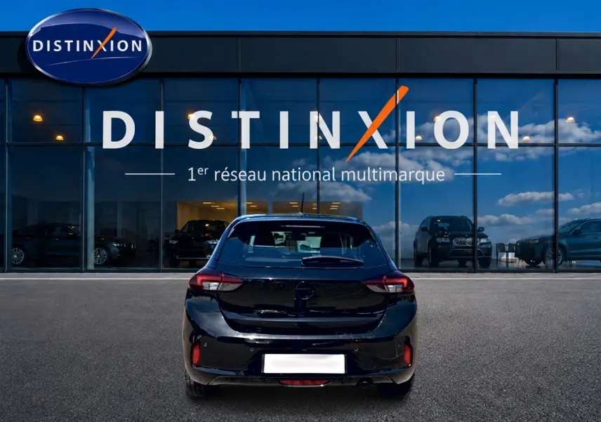 Vue arrière d'une Opel Corsa 1.2 turbo 100 édition noire, stationnée devant une vitrine avec logo Distinxion.