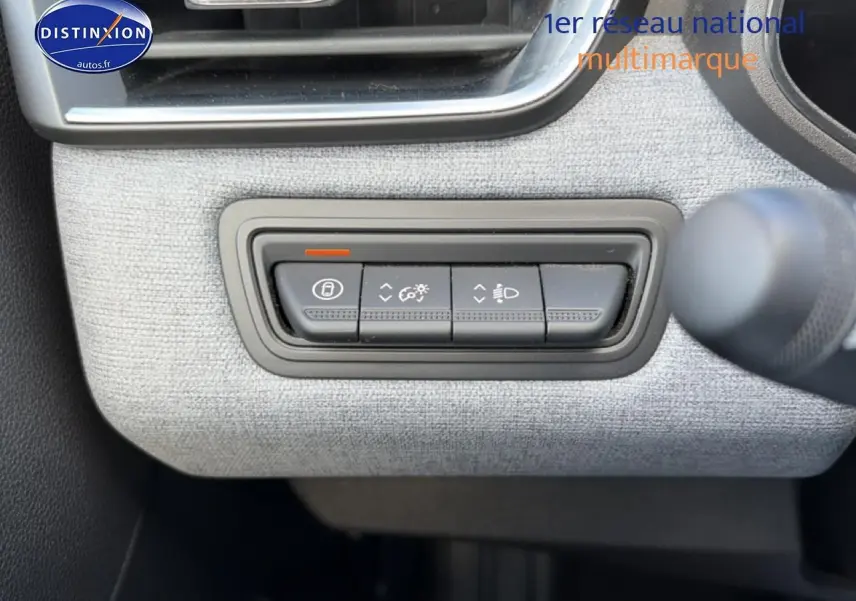 Gros plan sur les commandes d’éclairage et verrouillage sur tableau de bord gris clair de Renault Clio V 2025.