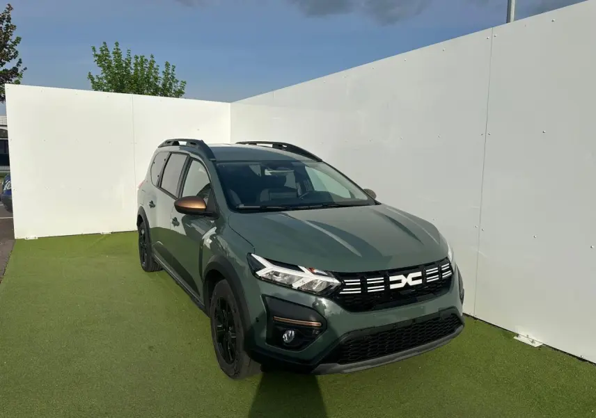 Vue 3/4 avant droite du Dacia Jogger kaki lichen avec calandre noire et rétroviseurs brun cuivré.