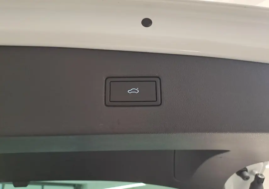 Bouton d'ouverture électrique du coffre sur la partie intérieure du hayon blanc pur d'un Volkswagen Tiguan 2023.