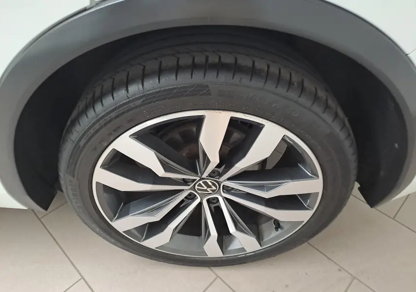 Gros plan sur la jante alliage 20'' Suzuka bicolore du Volkswagen Tiguan blanc pur, pneu 255/40 R20 visible.