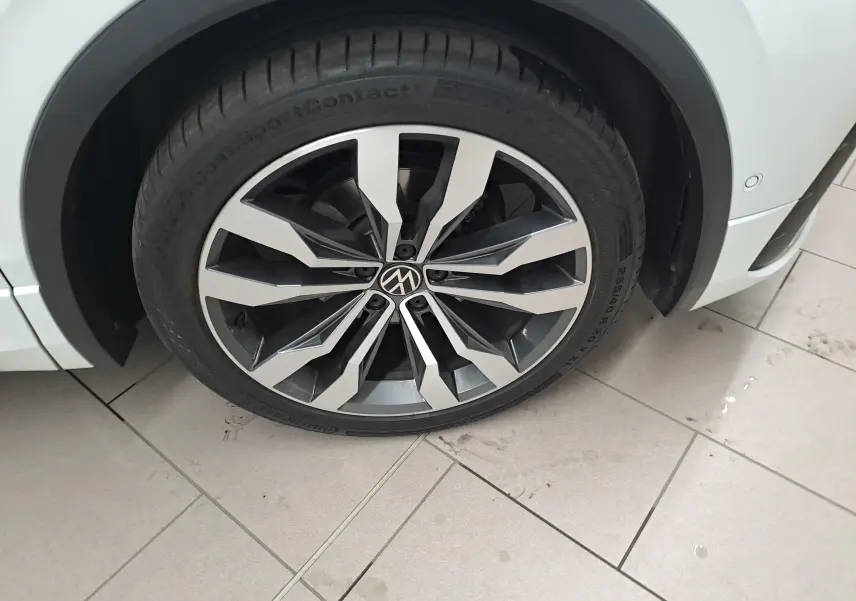 Gros plan sur la jante alliage 20'' Suzuka noire et argent du Volkswagen Tiguan blanc pur, côté avant droit.