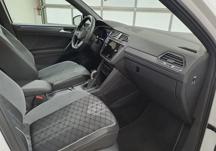 Vue intérieure côté conducteur du Volkswagen Tiguan 2.0 TDI R-Line 2023, sièges tissu gris à motif losanges.
