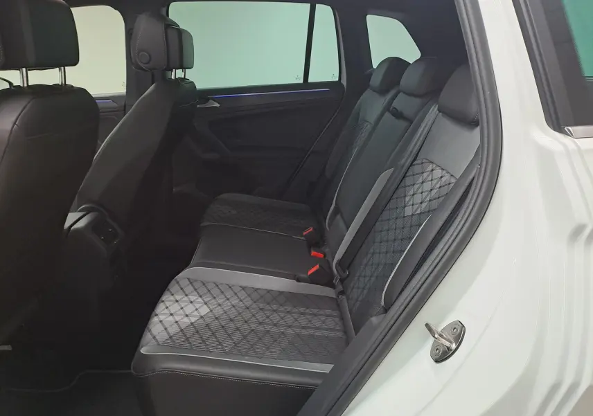 Vue intérieure côté droit des sièges arrière en tissu et cuir noir du Volkswagen Tiguan blanc pur 2023.