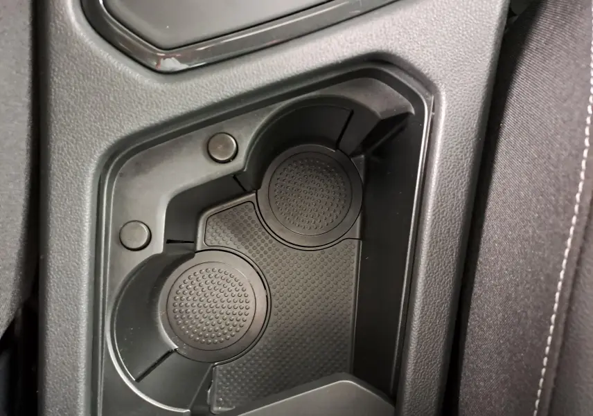Gros plan sur le porte-gobelets noir intégré à la console centrale du Volkswagen Tiguan blanc pur 2023.
