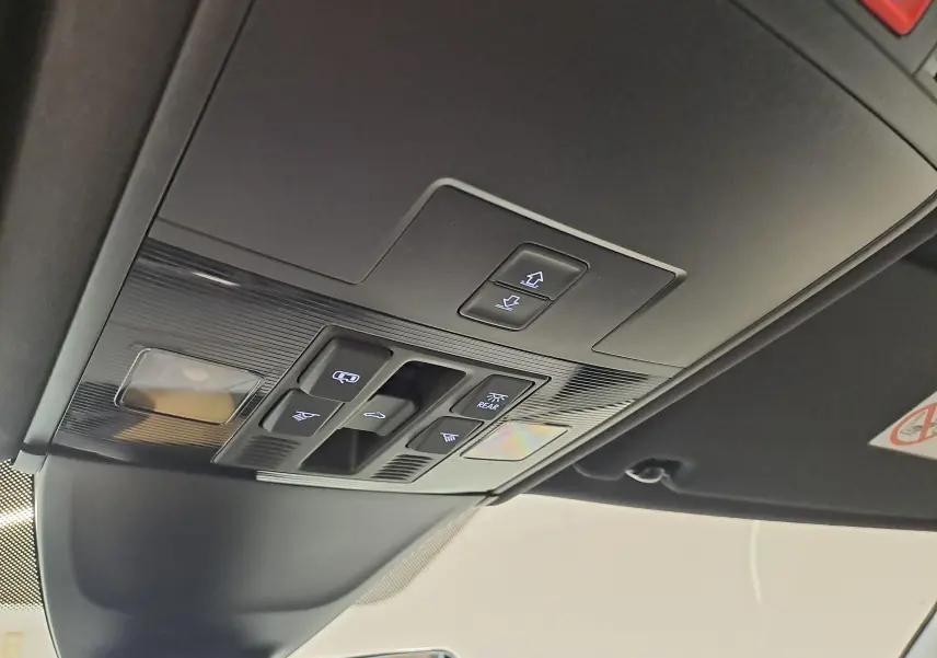 Vue intérieure en plongée sur les commandes du toit ouvrant panoramique du Volkswagen Tiguan blanc pur 2023.