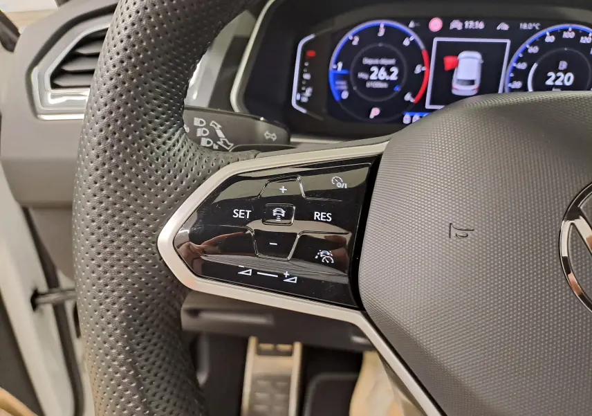 Gros plan sur la partie gauche du volant en cuir perforé du Volkswagen Tiguan 2023 avec commandes de régulateur adaptatif.