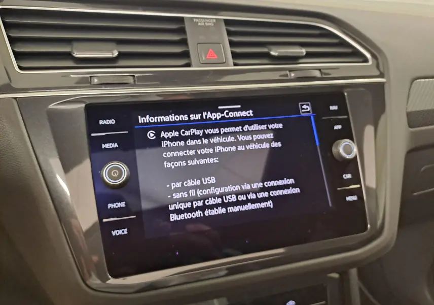 Écran tactile central du Volkswagen Tiguan blanc 2023 affichant les informations App-Connect en intérieur.
