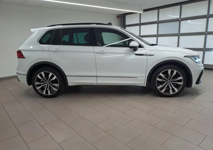 Profil droit du Volkswagen Tiguan blanc pur 2023 avec jantes alliage 20'' Suzuka et toit ouvrant panoramique.