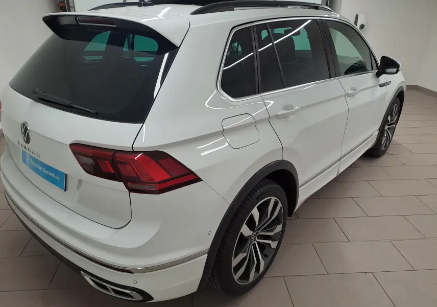Vue 3/4 arrière droite du Volkswagen Tiguan blanc pur 2023 avec jantes alliage 20'' Suzuka et toit ouvrant panoramique.