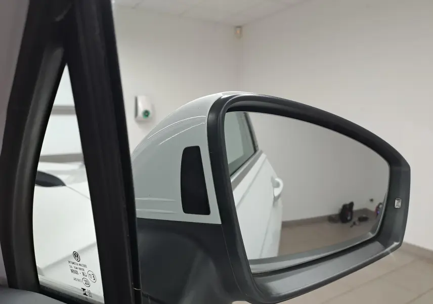 Rétroviseur extérieur droit blanc du Volkswagen Tiguan 2023, vue rapprochée avec reflet de la porte arrière.