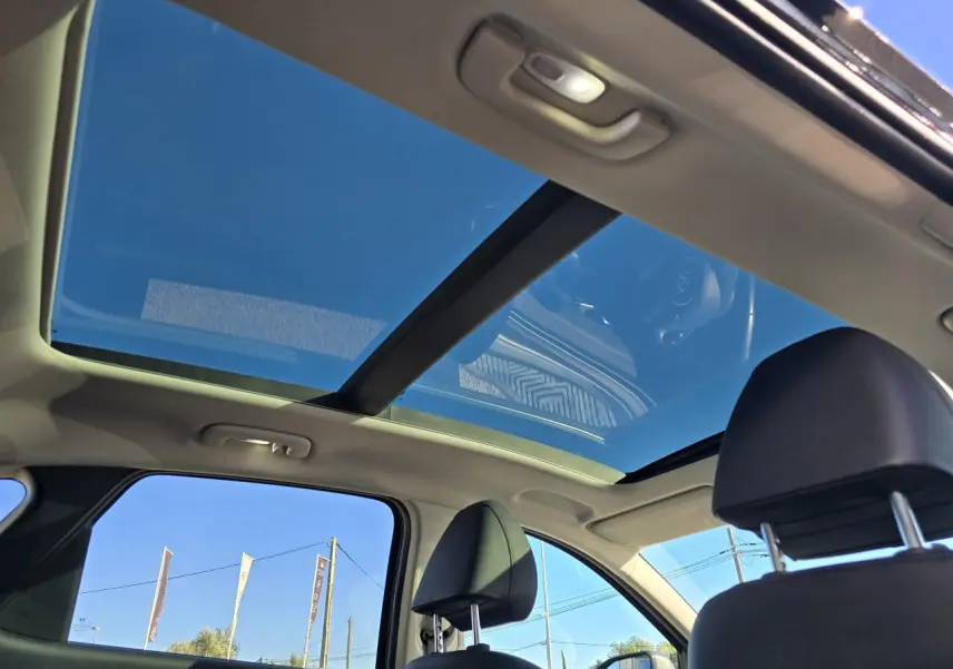 Vue intérieure du toit ouvrant panoramique du Hyundai Tucson noir Phantom Metal, avec ciel bleu visible à travers le verre.
