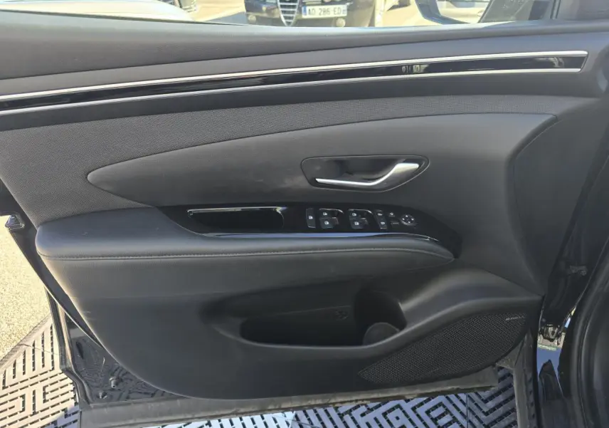 Vue intérieure du panneau de porte avant gauche noir avec commandes électriques et haut-parleur Bose sur Hyundai Tucson 2021.