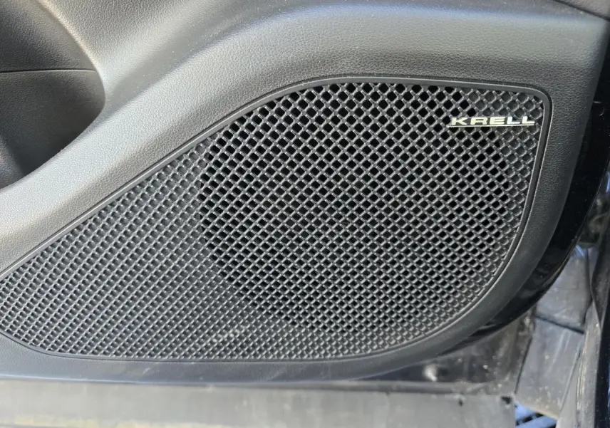 Gros plan sur le haut-parleur Krell intégré à la porte côté gauche du Hyundai Tucson noir Phantom Metal.
