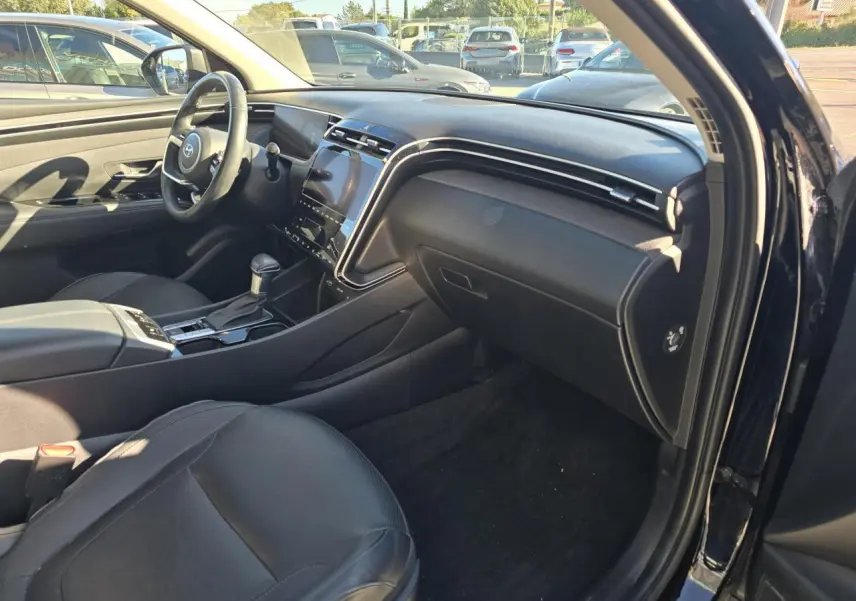 Vue intérieure côté passager du Hyundai Tucson noir Phantom Metal 2021, mettant en valeur le tableau de bord et la sellerie cuir noire.