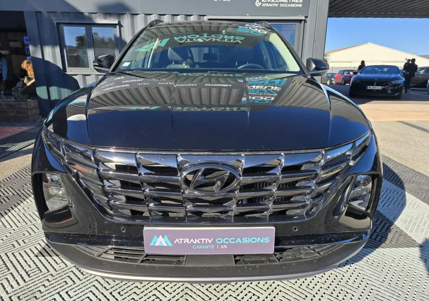 Vue frontale du Hyundai Tucson noir Phantom Metal avec calandre chromée et projecteurs bi-LED visibles.