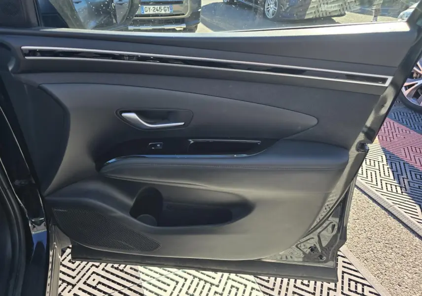 Vue rapprochée de la porte avant gauche noire Phantom Metal du Hyundai Tucson 2021 avec garniture intérieure en cuir et insert brillant.