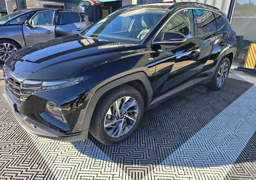 Hyundai Tucson noir Phantom Metal vu en 3/4 avant droit, avec jantes alliage et toit panoramique visible.