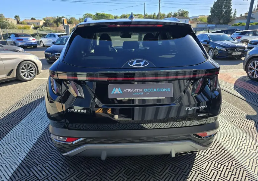 Vue arrière d'un Hyundai Tucson noir Phantom Metal avec feux arrière reliés et double sortie d'échappement visible.