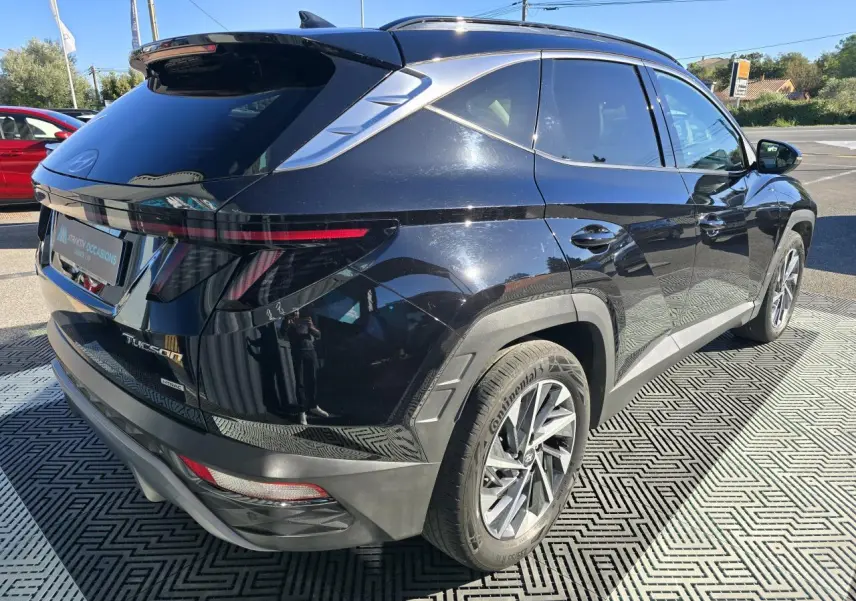 Vue 3/4 arrière droite du Hyundai Tucson noir Phantom Metal avec feux arrière LED fins et jantes alliage modernes.