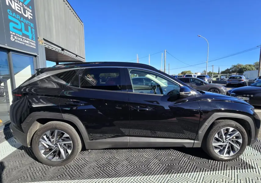 Vue latérale côté droit d'un Hyundai Tucson noir Phantom Metal 2021, soulignant ses lignes anguleuses et ses jantes alliage.