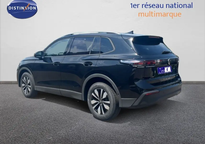 Vue 3/4 arrière droite d’un Volkswagen Tiguan noir Grenadilla Metal avec jantes bi-ton et feux arrière LED.