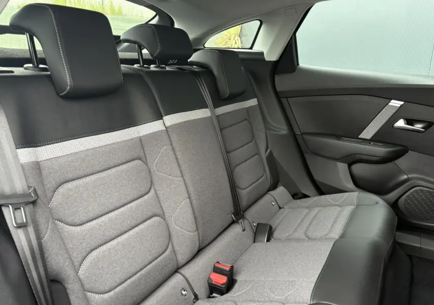 Vue intérieure de la banquette arrière grise et noire de la Citroën C4 2024, côté droit avec ceinture et appuie-têtes visibles.